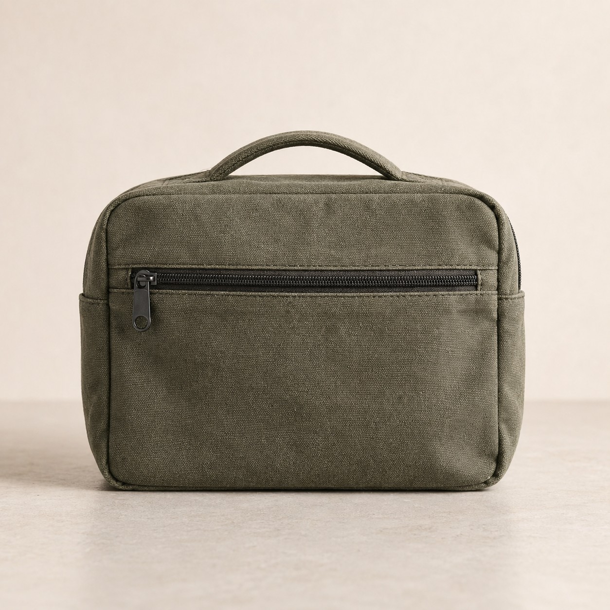 Closed olive canvas travel organizer bag with exterior zipper pocket.